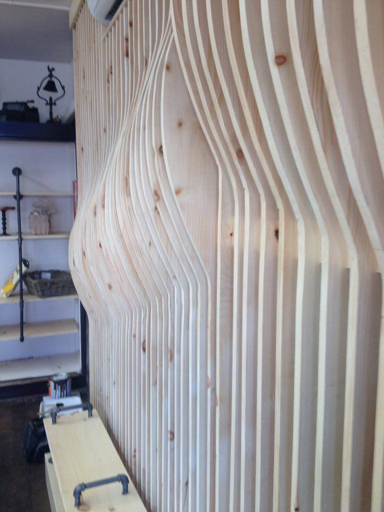 Clear-coat pine undulating wall is a perfect contrast with the galvanized pipe and antiques at Holmesburg Bakery