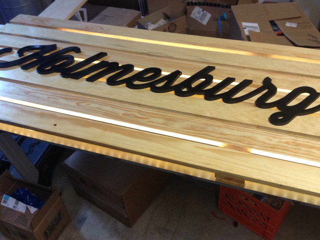 New exterior sign for Holmesburg Bakery made from clear-coat pine, new font, and backlit