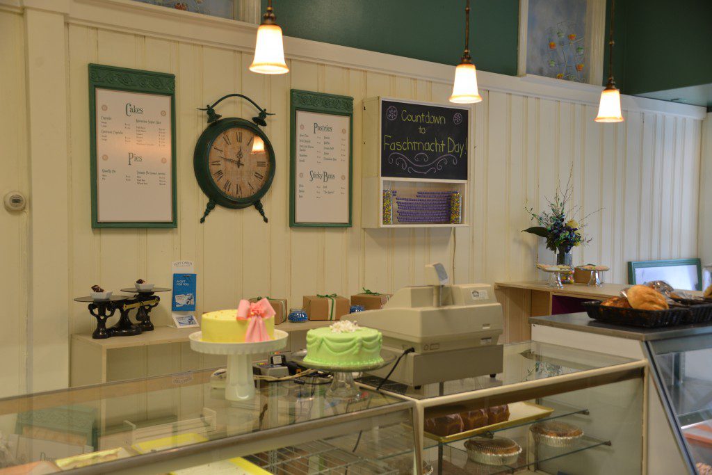 Save My Bakery AFTER: Schubert's Bakery is detailed with new menus, wall art, and display pedestals to show off the new cake designs.