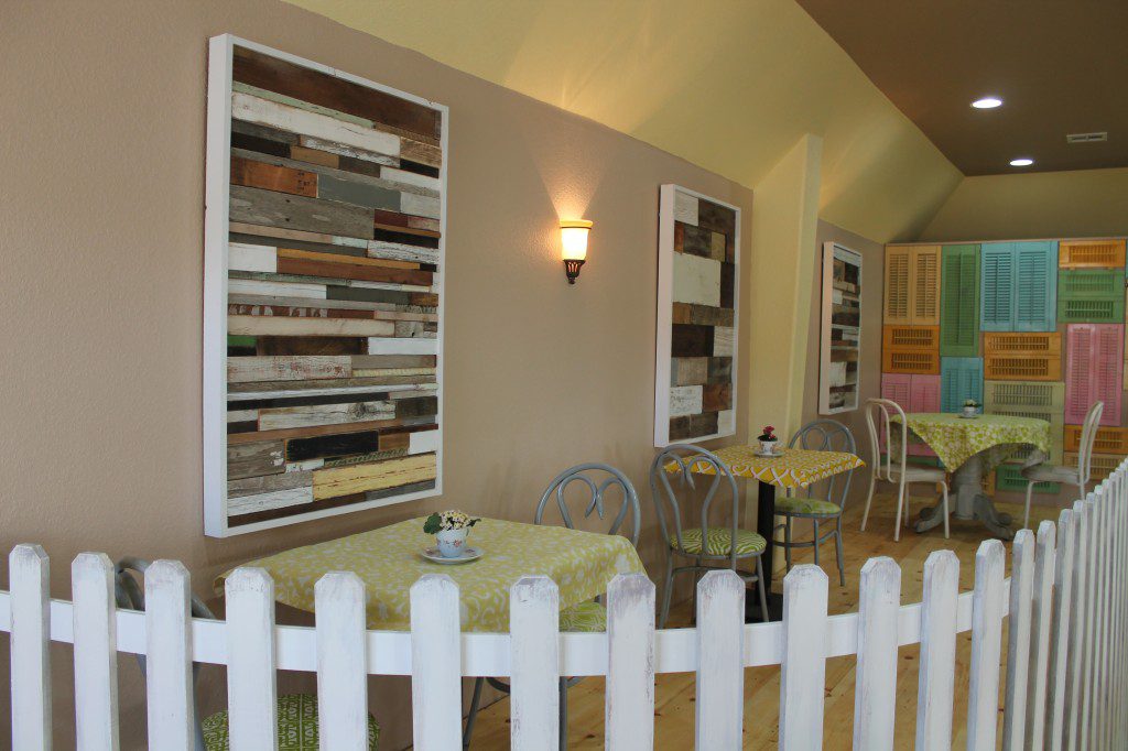 Picket fence with the salvage wood wall art and salvage shutters on a pine floor platform create a fun and more intimate dining experience at Lori's.