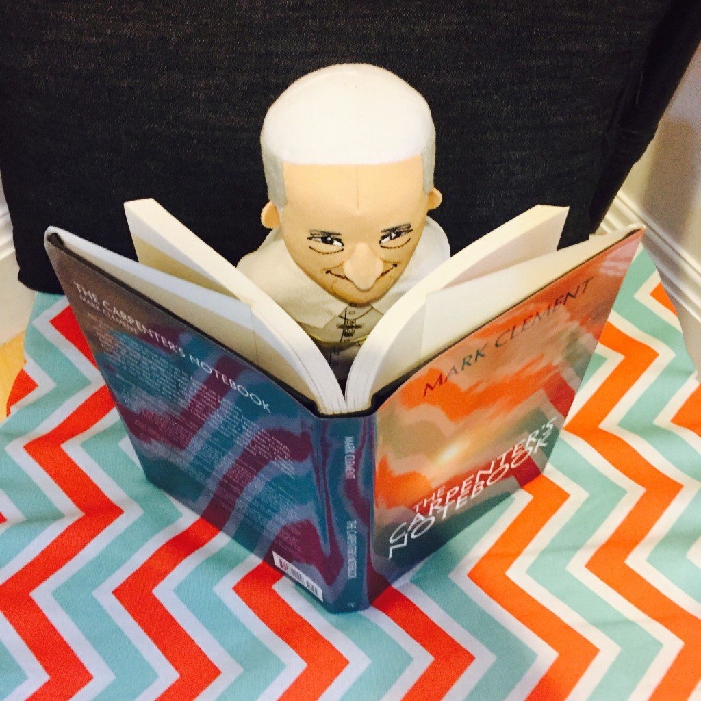 Plush Pope Francis wanted to know more about us, so he's reading the novel Mark wrote called 'The Carpenter's Notebook.'