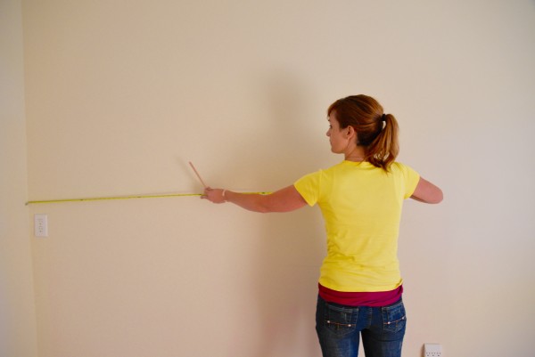 Theresa taking measurements for the wainscoting and chair rail for this girl's bedroom