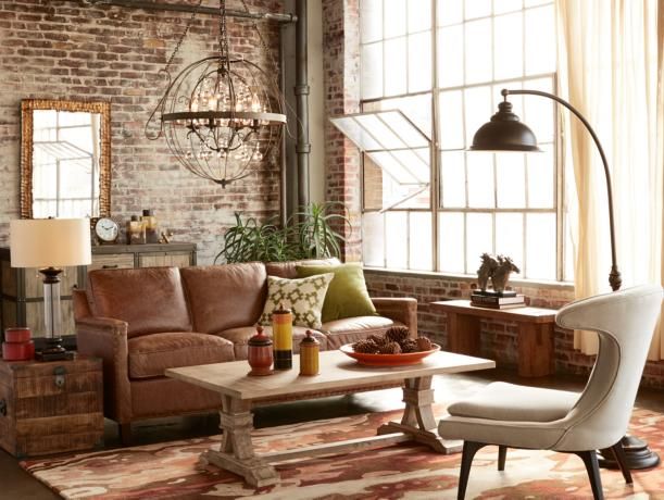 Bronze pendant, gold mirror, and an oil rubbed bronze wall lamp mix effortfessly in this loft-style living room