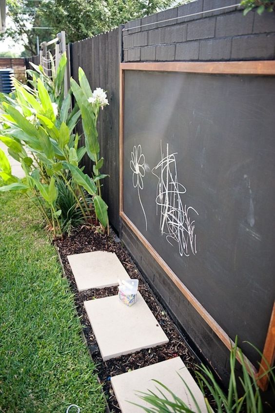 Creating a play area outside is more than just sprinklers and plastic toys. How about a chalkboard wall