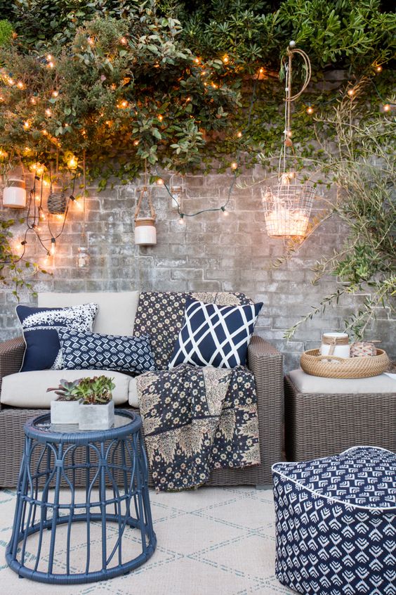Pillows, throws, an outdoor rug and lighting can completely transform a little outdoor seating spot
