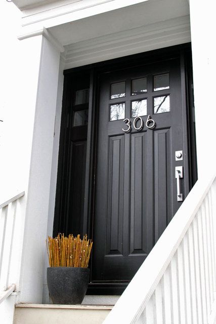  A black door can be a bold power statement. With the font of the house numbers and plant decor, the entry is giving a modern and cool vibe.