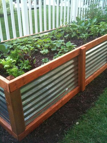 This galvanized steel and stained wood planter is visually easy to see, and helps define the yard.