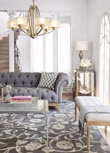 Parisian pied-a-terre, city apartment living room mixes metals of brass in the chandelier with nickel in the coffee table.