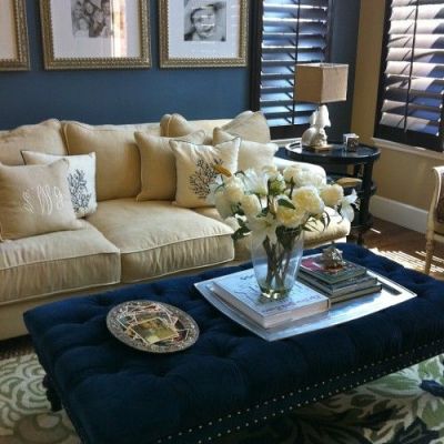 Painting a wall a darker color can create the illusion that the wall is receding into the background, like here with the navy wall and tufted coffee table.