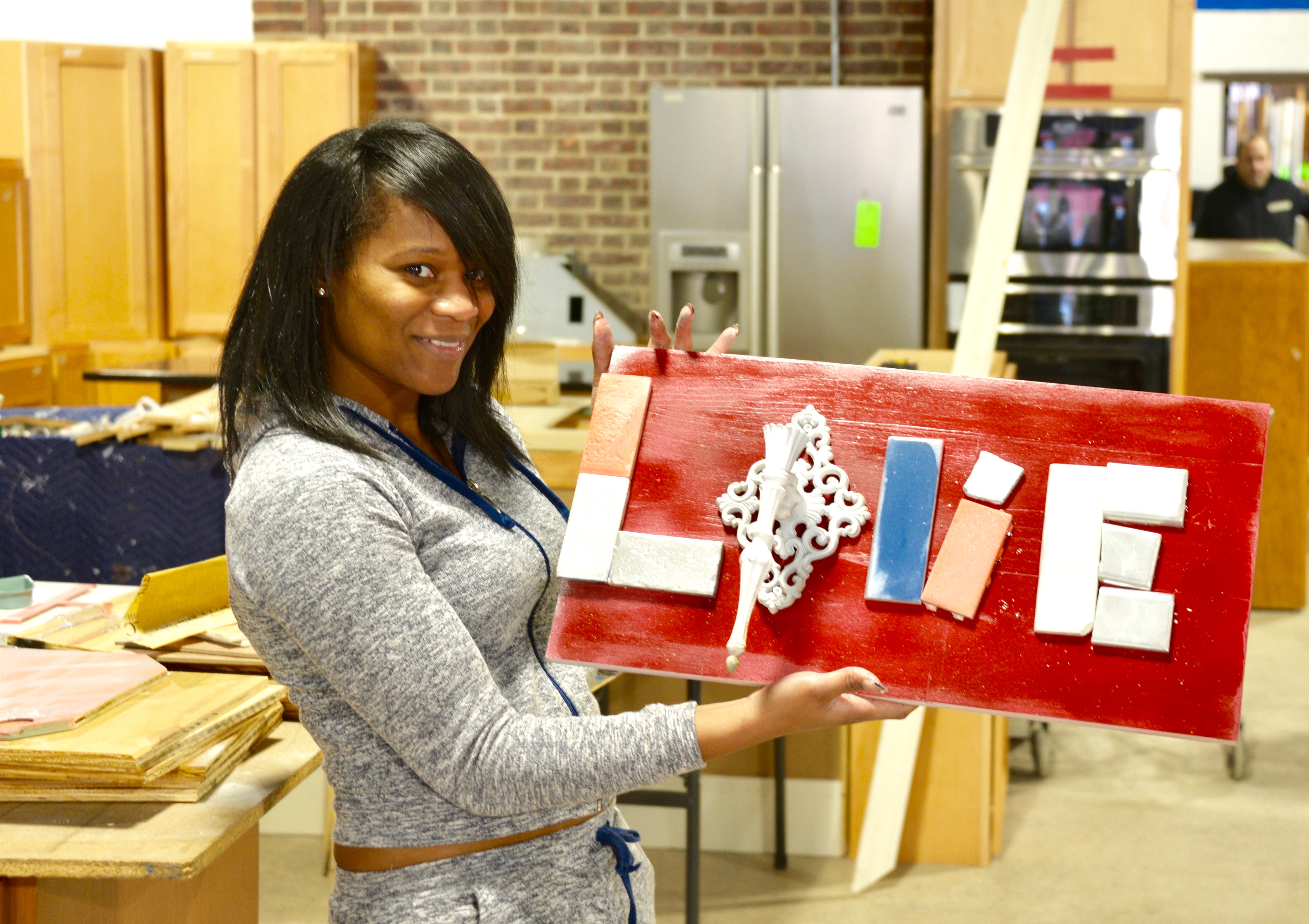 Jessica Massaquoi made this Love wall art with a wall sconce and tile at the Habitat for Humanity ReStore workshop.