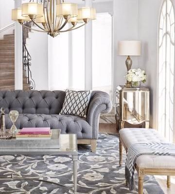 Parisian pied-a-terre, city apartment living room mixes metals of brass in the chandelier with nickel in the coffee table.
