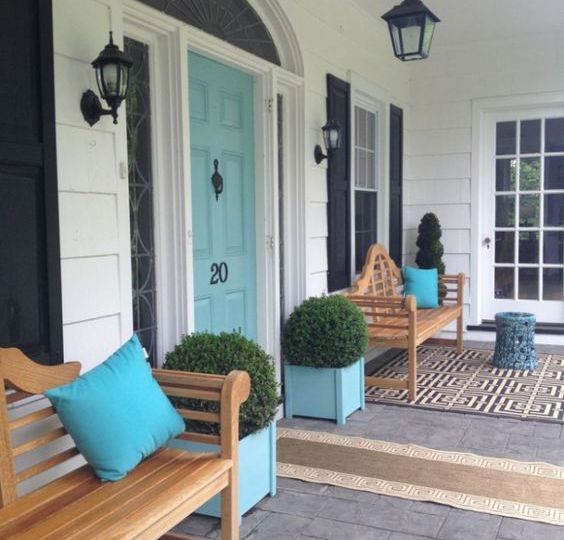 The black-white-and-wood porch might make most select a black or wood door. The aqua blue front door gives personality about the creamy white siding and black accents.