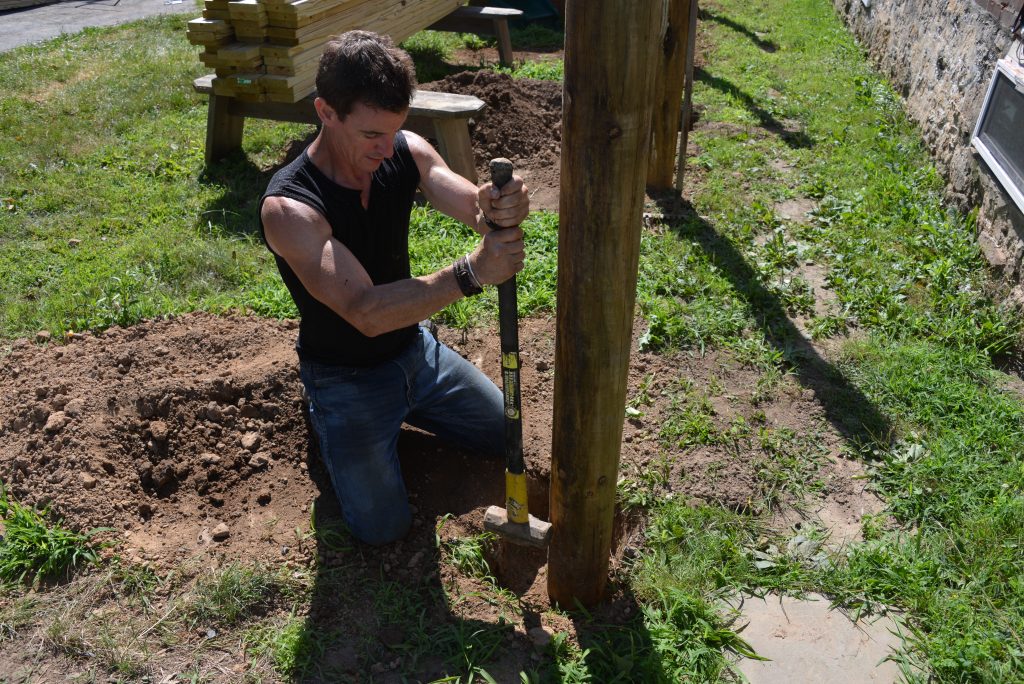 building a wood fence, using a sledge hammer